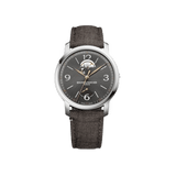 Front-facing view of the Baume & Mercier Classima Special Edition M0A10718 men's watch, featuring a grey sun satin-finished dial with diagonal lines, open balance aperture at 12 o'clock, power reserve indicator at 6 o'clock, rose gold-tone leaf hands, Arabic numerals, polished stainless steel case, and a brown Holland & Sherry fabric strap.