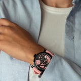 Speake Marin Openworked Dual Time Pink Automatic GMT 42mm Watch 414209430 worn on the wrist, showing its bold pink dial and black DLC titanium case. The pink rubber strap and black DLC titanium pin buckle complete this limited edition travel watch.