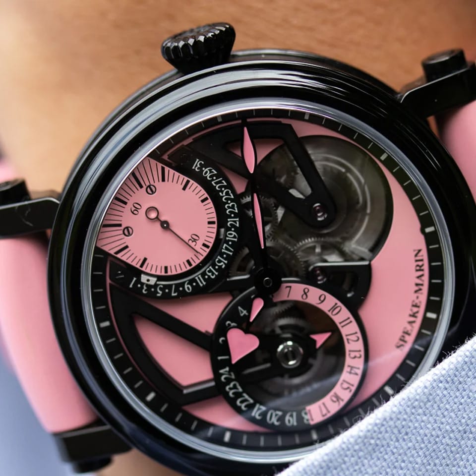 Speake Marin Openworked Dual Time Pink Automatic GMT 42mm Watch 414209430 styled in a travel-inspired luxury setting, its vivid pink dial standing out against black DLC titanium. This limited edition independent timepiece tracks two time zones with an in-house automatic movement.