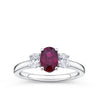 1.33 Carat Ruby and 0.40 Carat TW Diamond Ring in 18ct White Gold — A vivid oval-cut ruby sits at the heart of this trilogy design, flanked by two natural oval-cut diamonds of G-H colour and VS-SI clarity.