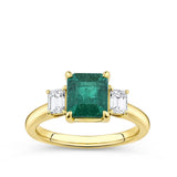 2.10 Carat Emerald and 0.40 Carat TW Diamond Trilogy Ring in 18ct Yellow Gold — A 2.10 carat emerald-cut natural emerald sits at the centre of this trilogy design, flanked by two natural emerald-cut diamonds. The 18ct yellow gold setting provides a warm, rich contrast to the emerald's vivid green hue.