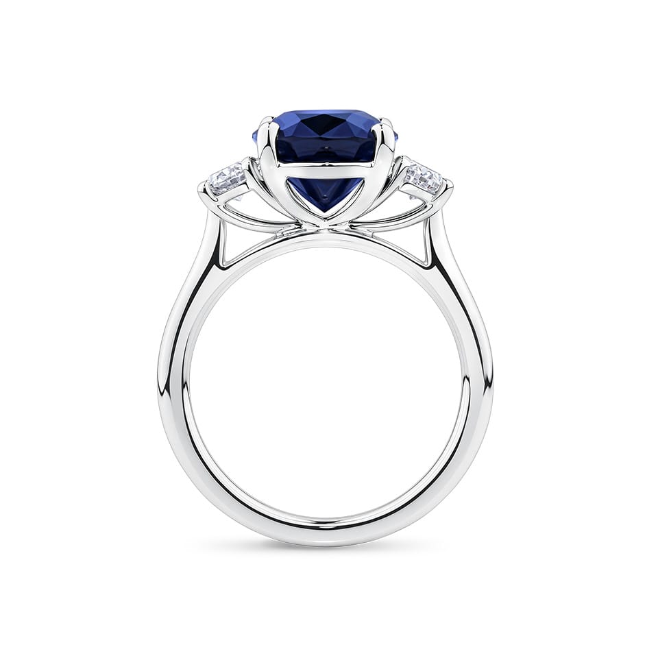 5.54 Carat Sapphire and 0.40 Carat TW Diamond Trilogy Ring in 18ct White Gold — Viewed from the front, the ring showcases its trilogy design with the oval-cut sapphire set above matching oval-cut diamonds on either side. The 18ct white gold setting frames the stones in a bright, cool tone.