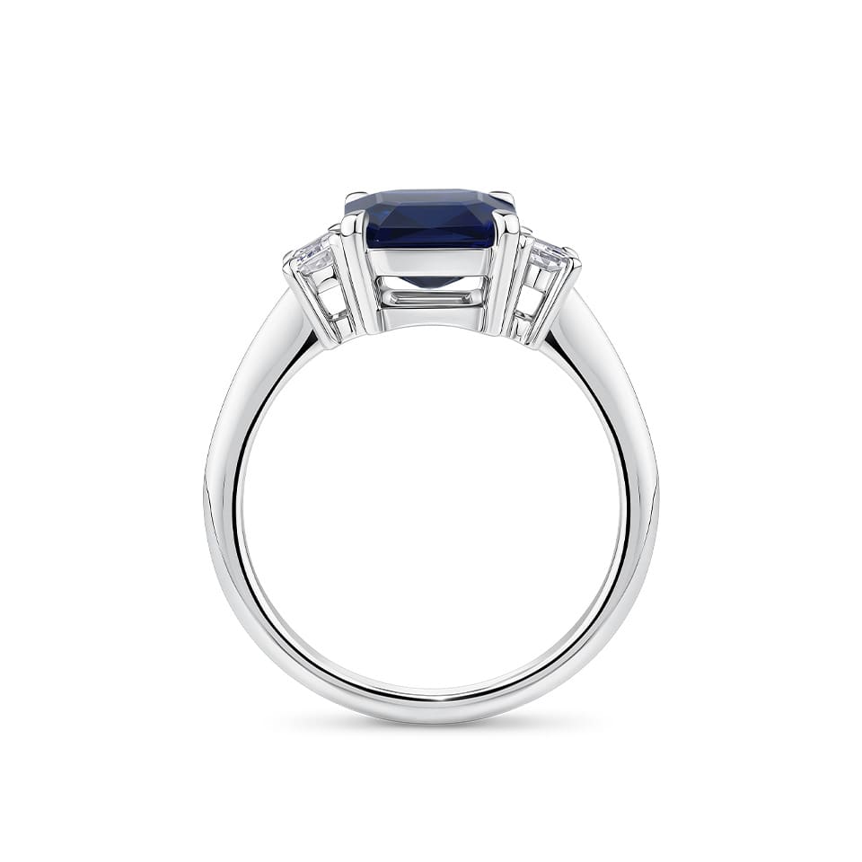 3.68 Carat Sapphire and 0.42 Carat TW Diamond Trilogy Ring in 18ct White Gold — Viewed from the front, the ring showcases its trilogy design with the emerald-cut sapphire set above matching emerald-cut diamonds on either side. The 18ct white gold setting frames the stones in a bright, cool tone.