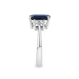 3.68 Carat Sapphire and 0.42 Carat TW Diamond Trilogy Ring in 18ct White Gold — This side profile highlights the ring's claw-set gallery and the natural emerald-cut diamonds set along each shoulder. The 18ct white gold band maintains a slim, elegant silhouette from every angle.
