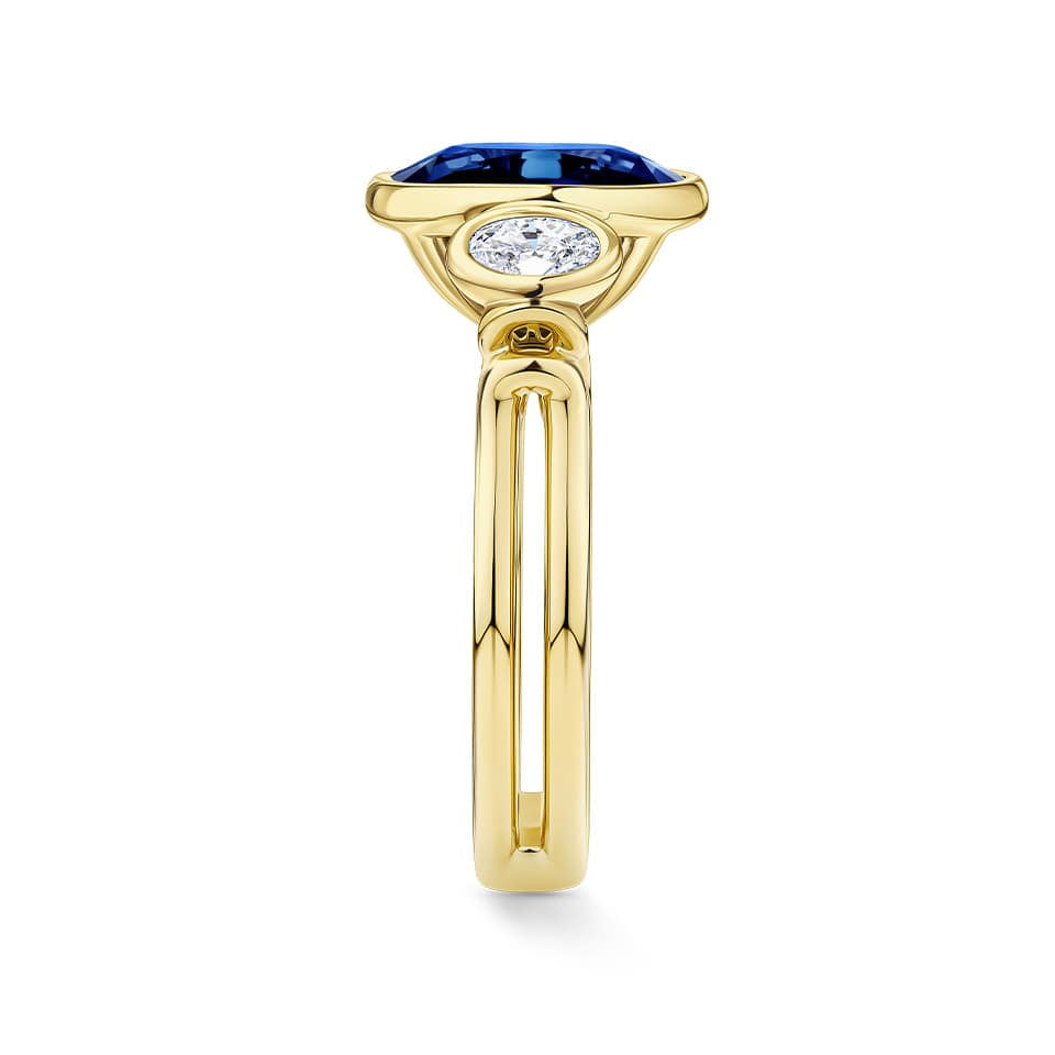 Side view of the Sapphire and Diamond Trilogy Ring in 18ct yellow gold by Hardy Brothers, highlighting the bezel-set sapphire and diamond side stones.