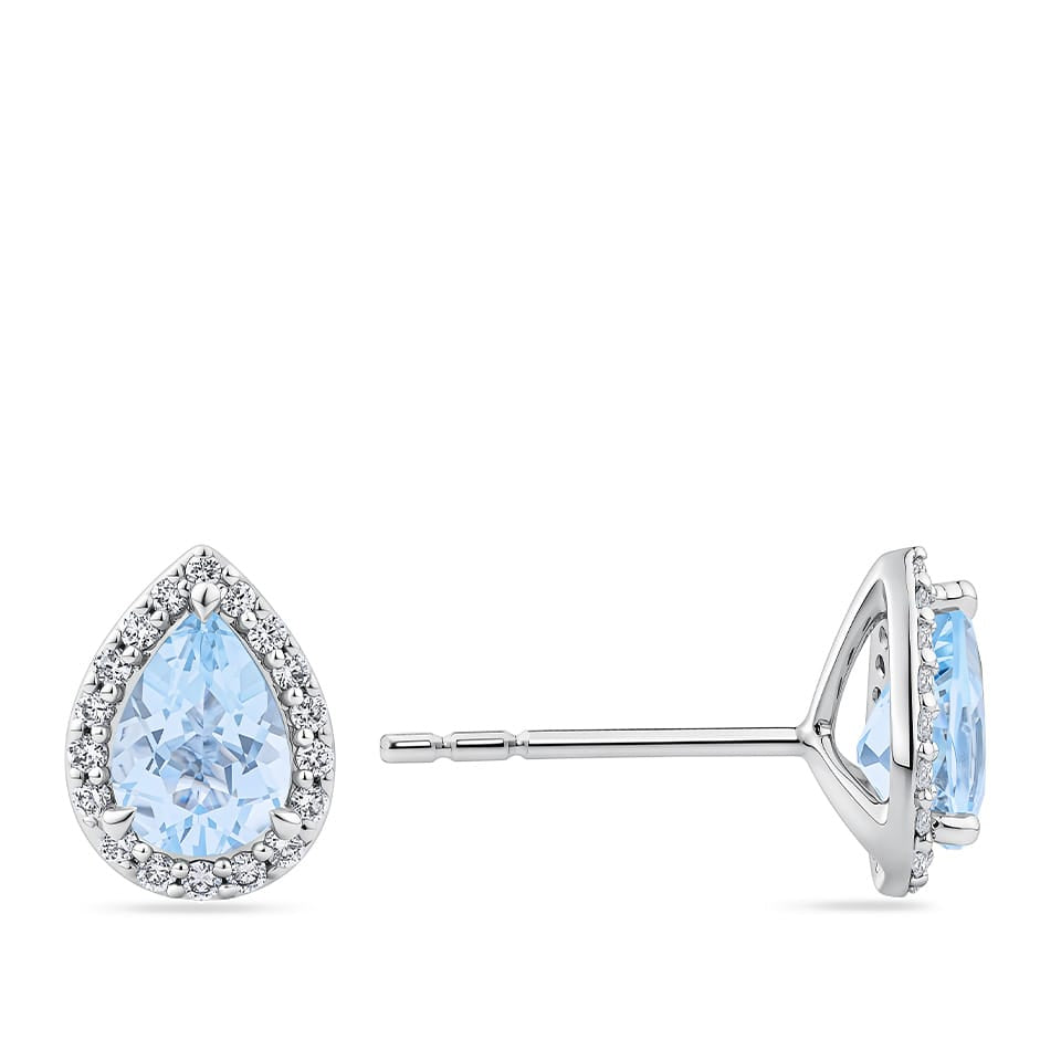 A pair of Pear Cut Aquamarine and Diamond Halo Stud Earrings in 18ct White Gold. shown on a plain white background with one earring facing forward and the other in side profile.