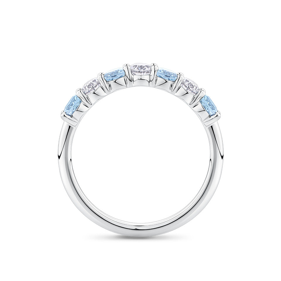 Side-on view of the Aquamarine and Diamond Half Eternity Ring in 18ct white gold by Hardy Brothers, highlighting the claw-set stones and polished gold underside.
