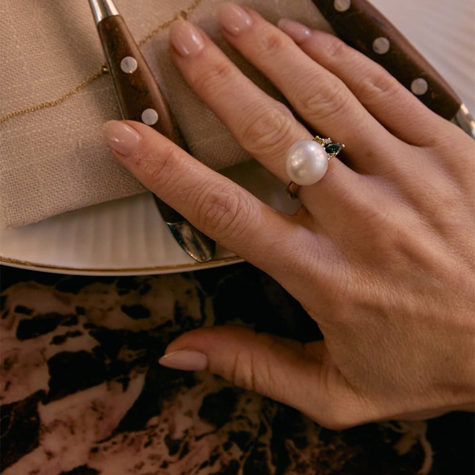 A close-up of a hand wearing the Elysian Pearl and Tourmaline Ring in 18ct Yellow Gold 9PRSPTY01N
