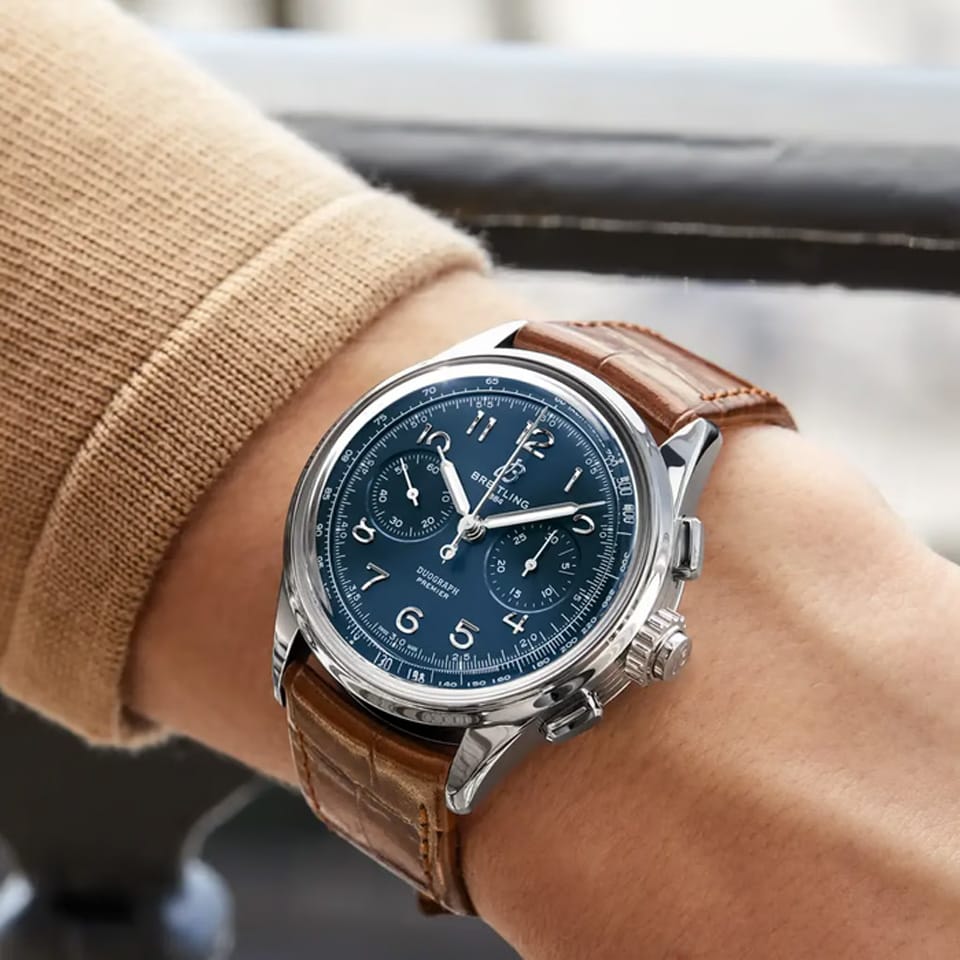 Breitling Premier B15 Duograph 42mm Watch AB1510171C1P1 is shown worn on the wrist, highlighting the proportions of its 42mm case and curved alligator strap. The split-second rattrapante chronograph function is powered by the COSC-certified Caliber B15 with an approximate 70-hour power reserve.