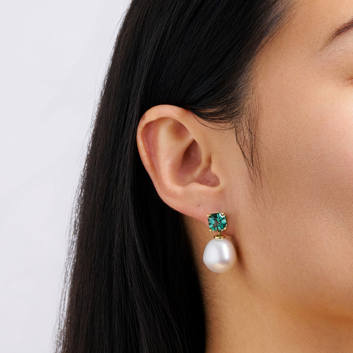 Close-up detail of the South Sea Pearl and Tourmaline Stud Earrings in 18ct yellow gold by Hardy Brothers, highlighting the cushion cut teal tourmaline and the 12mm South Sea pearl.