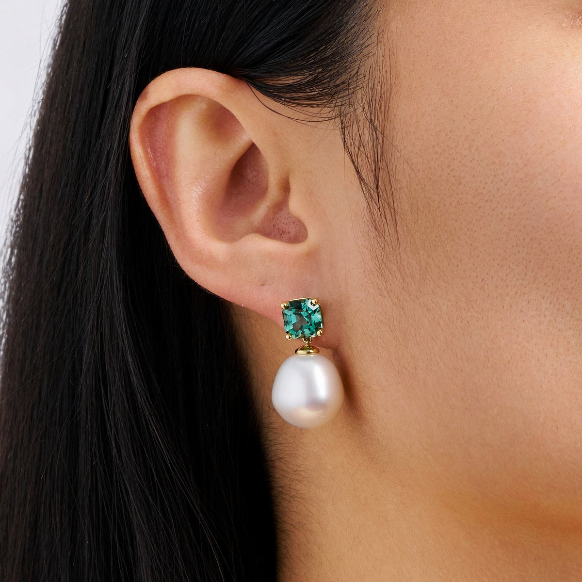 Close-up detail of the South Sea Pearl and Tourmaline Stud Earrings in 18ct yellow gold by Hardy Brothers, highlighting the cushion cut teal tourmaline and the 12mm South Sea pearl.