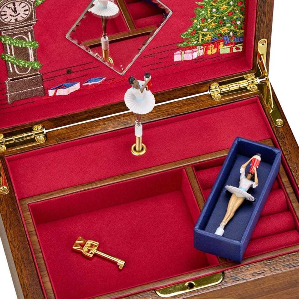 WOLF Ballet Musical Jewellery Box in Swan Lake Walnut Wood, item 190106, showing its jewellery compartments up close. Eight compartments in the top section and one large lower compartment are lined with blue Ultrasuede.