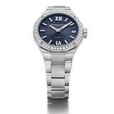 Overhead view of the Baume & Mercier Riviera M0A10765 ladies' watch, displaying the full watch face-up — the night blue dial with tone-on-tone wave transfers, riveted rhodium-plated Roman numerals and indexes, faceted rhodium-plated hands, and the sparkling 44 brilliant-cut diamond-set bezel catching the light, with the polished stainless steel bracelet laid out symmetrically on either side of the twelve-sided case.
