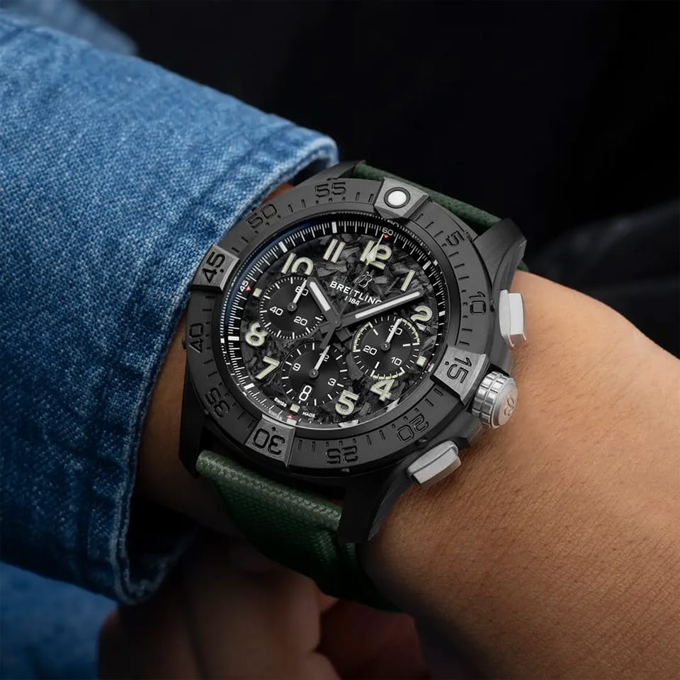 Breitling Super Avenger B01 Chronograph 46mm Watch SB0148101B1X1 is shown worn on the wrist, highlighting the proportions of its 46mm case and khaki green strap. This chronograph delivers 300m water resistance and is powered by the Breitling Manufacture Caliber 01 with an approximate 70-hour power reserve.