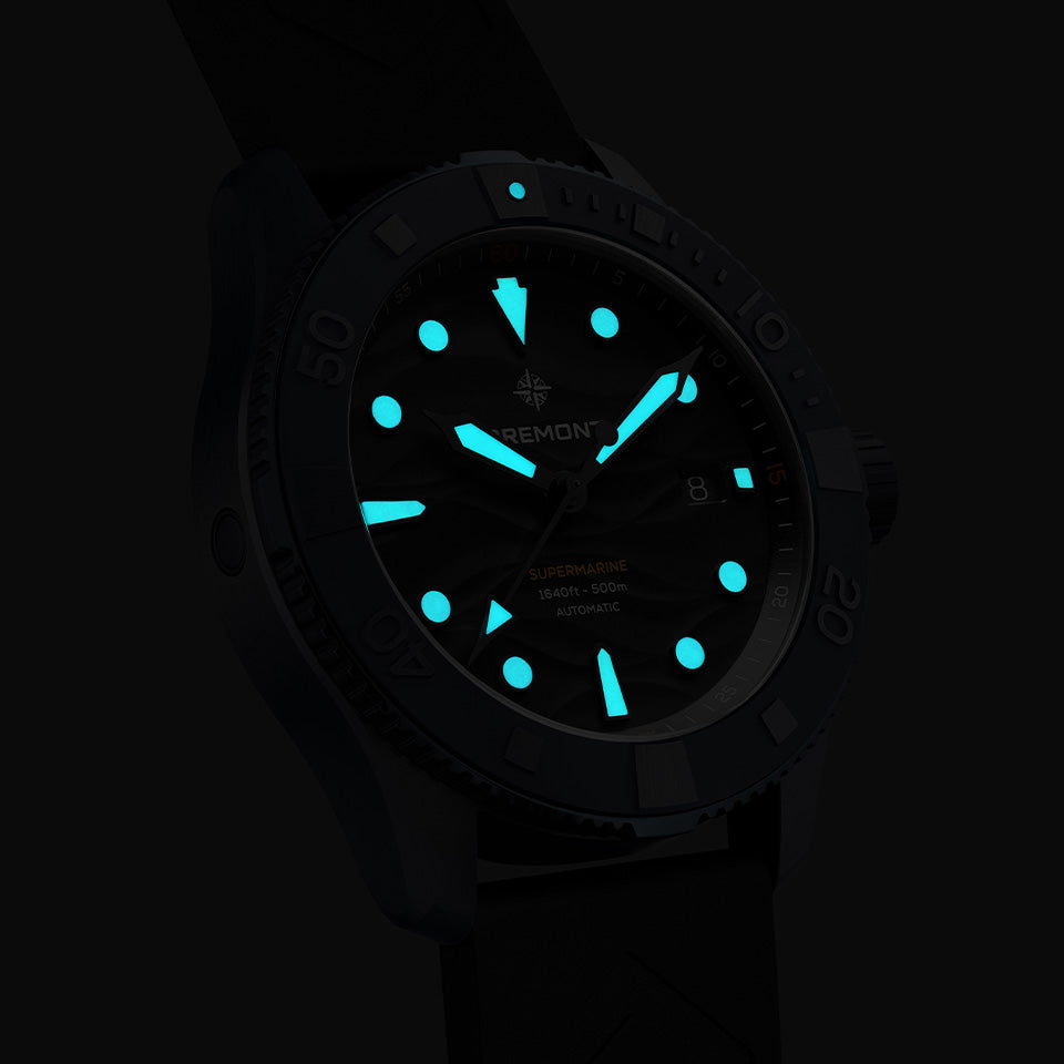 Bremont Supermarine Full Ceramic Deep Blue Automatic Men’s 43mm Watch SM43-DT-BLCER-BK-L-S showing its lume in low light. The indexes and hands glow blue from their Super-LumiNova fill.