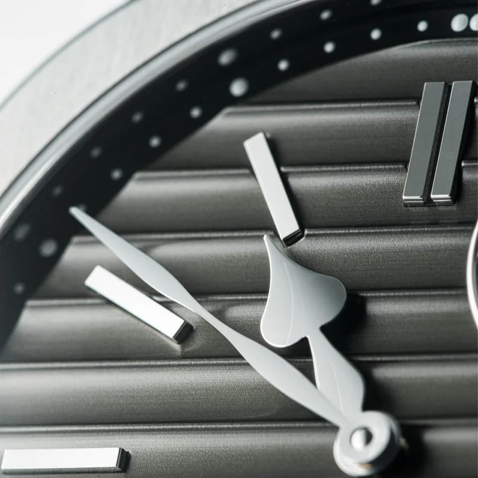 Close up of the Speake Marin Ripples Black Original Automatic 40.30mm Watch 604015040 dial, showing the signature ripple texture and black small seconds counter at 1:30. Heart-shaped rhodium-plated hands, a Speake Marin signature, sweep across the polished indexes.