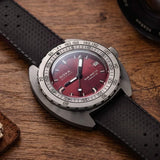 Front view of DOXA SUB 300 Ti5 Redcoral watch, 42.5mm grade 5 titanium cushion case, red coral dial with oversized orange minute hand, patented dual-scale dive bezel, screw-down crown, and contrasting black rubber strap with folding clasp — Ref. 823.50.161.20