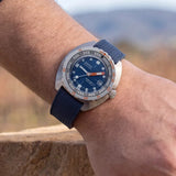 Front view of DOXA SUB 300 Ti5 Caribbean watch, 42.5mm grade 5 titanium cushion case, Caribbean Blue dial with oversized orange minute hand, patented dual-scale dive bezel, screw-down crown, and blue rubber strap with folding clasp — Ref. 823.50.201.32