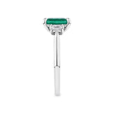 1.62 Carat Emerald and 0.40 Carat TW Diamond Trilogy Ring in 18ct White Gold — This side profile highlights the ring's tapered gallery and the natural emerald-cut diamonds set along each shoulder. The 18ct white gold band maintains a slim, elegant silhouette from every angle