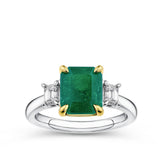 2.54 Carat Emerald and 0.40 Carat TW Diamond Trilogy Ring in 18ct Yellow and White Gold — A 2.54 carat emerald-cut natural emerald is framed by ornate yellow gold claws, flanked by two natural emerald-cut diamonds of H-I colour and VS-SI clarity. The 18ct yellow and white gold setting creates a striking two-tone contrast.
