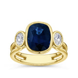 5.63 Carat Oval Cut Sapphire and Diamond Trilogy Ring in 18ct yellow gold from Hardy Brothers Jewellers, shown front-on to display the scale of the centre sapphire.