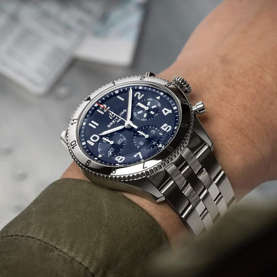 Breitling Classic AVI Automatic Chronograph 42mm Watch A233801A1C1A1 is shown worn on the wrist, highlighting the proportions of its 42mm case and stainless steel bracelet. This COSC-certified chronograph is powered by the Breitling Caliber 23 with an approximate 48-hour power reserve.
