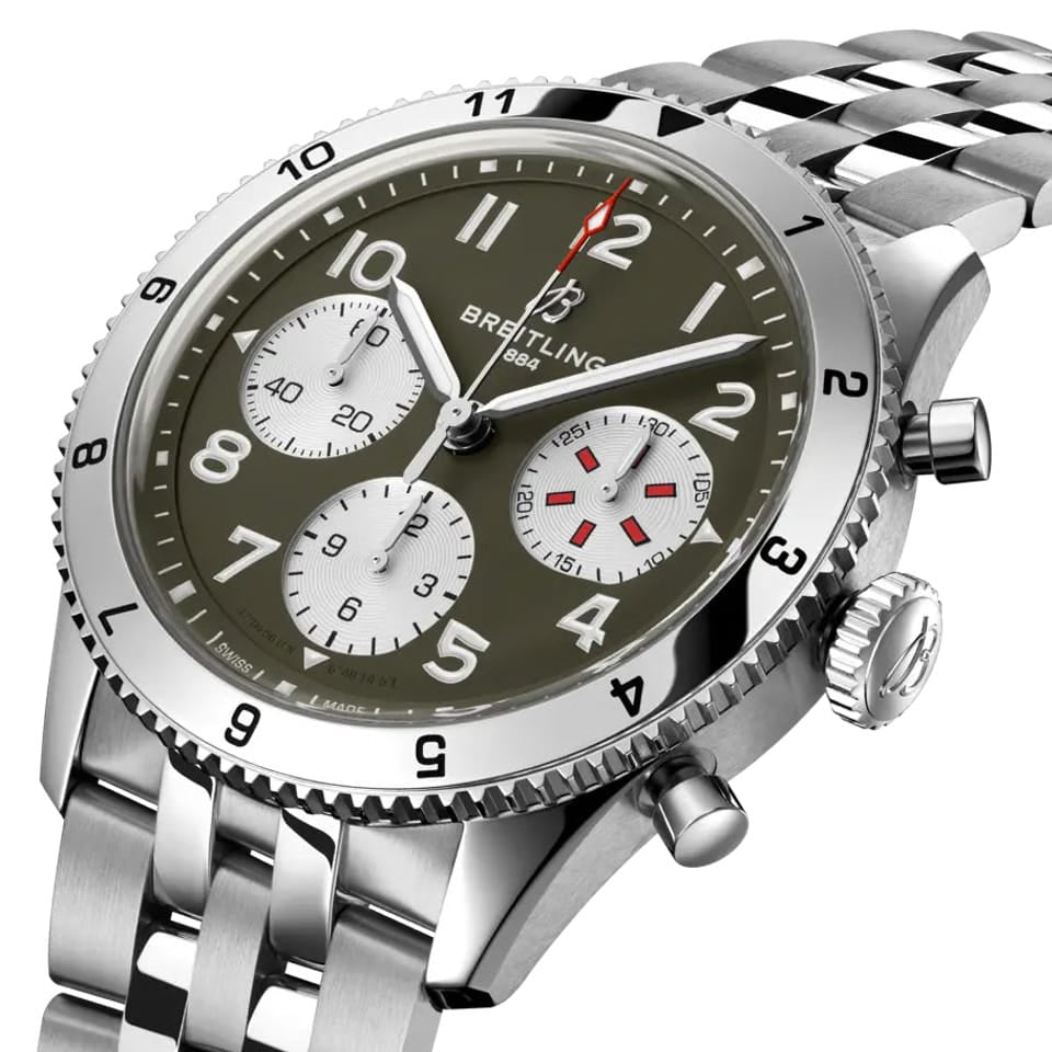 Breitling Classic AVI Automatic Chronograph 42mm Watch A233802A1L1A1 shows the bidirectional ratcheted bezel and cambered sapphire crystal from an angled perspective. The stainless steel bracelet connects seamlessly to the 42mm case.