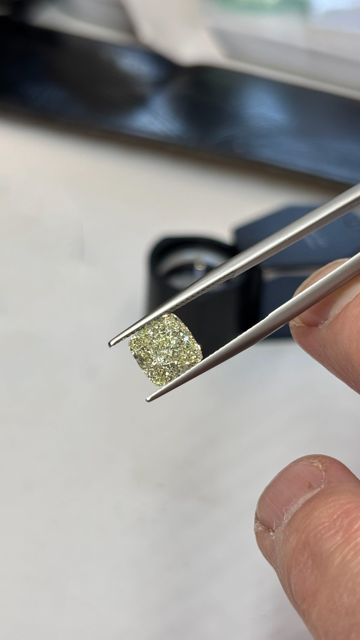 Natural Yellow Diamond in Cushion Cut shown between Diamond Tweezers