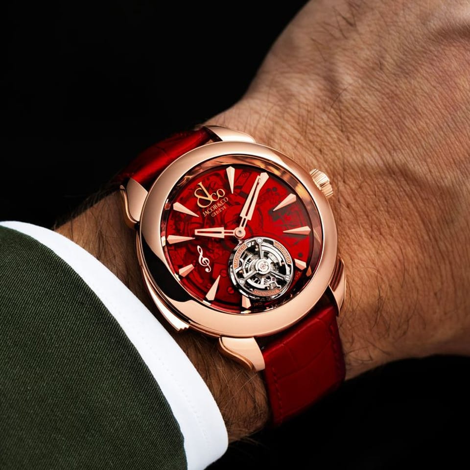 On wrist view of the Jacob & Co. Palatial Flying Tourbillon Minute Repeater 18K Rose Gold Manual 43mm Watch, reference PT500.40.NS.AC.A, demonstrating the proportions of the 43mm case against the wrist. The red alligator strap and 18K Rose Gold case sit together in a warm, tonal palette.