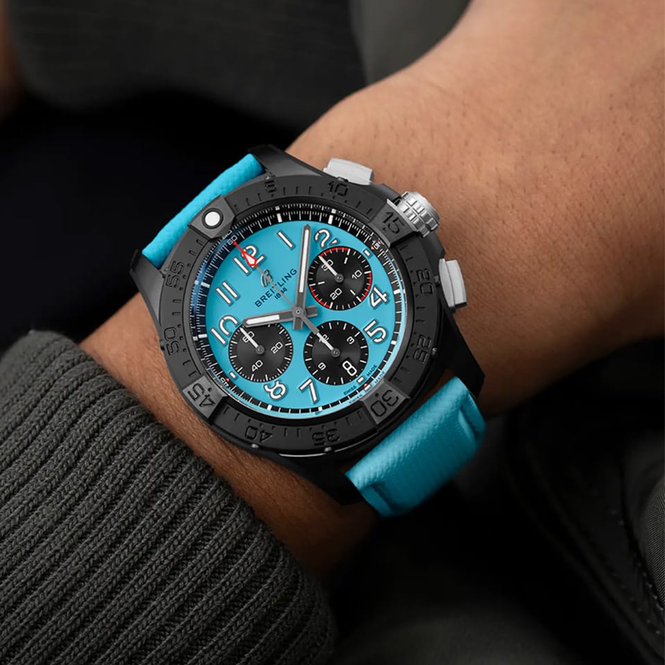 Breitling Avenger B01 Chronograph 42mm Watch SB0146101L1X1 is shown worn on the wrist, highlighting the proportions of its 42mm case and turquoise strap. This chronograph delivers 300m water resistance and is powered by the Breitling Manufacture Caliber 01 with an approximate 70-hour power reserve.