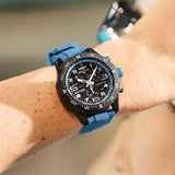 Breitling Endurance Pro Quartz Chronograph 44mm Watch X82310281B1S2 is shown worn on the wrist, highlighting the proportions of its 44mm case and blue rubber strap. This chronograph is powered by the COSC-certified SuperQuartz™ Caliber 82, roughly ten times more accurate than standard quartz.