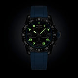 Breitling Endurance Pro Quartz Chronograph 44mm Watch X82310281B1S2 shows the luminous properties of its dial markers and hands in low light. The black dial and blue accents remain legible against the illuminated Breitlight® case in dark conditions.