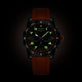 Breitling Endurance Pro Quartz Chronograph 44mm Watch X82310A51B1S2 shows the luminous properties of its dial markers and hands in low light. The black dial and orange accents remain legible against the illuminated Breitlight® case in dark conditions.