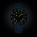 Breitling Endurance Pro Quartz Chronograph 38mm Watch X83310281B1S1 shows the luminous properties of its dial markers and hands in low light. The black dial and blue accents remain legible against the illuminated Breitlight® case in dark conditions.