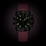 Breitling Endurance Pro Quartz Chronograph 38mm Watch X83310D41B1S1 shows the luminous properties of its dial markers and hands in low light. The black dial and pink accents remain legible against the illuminated Breitlight® case in dark conditions.