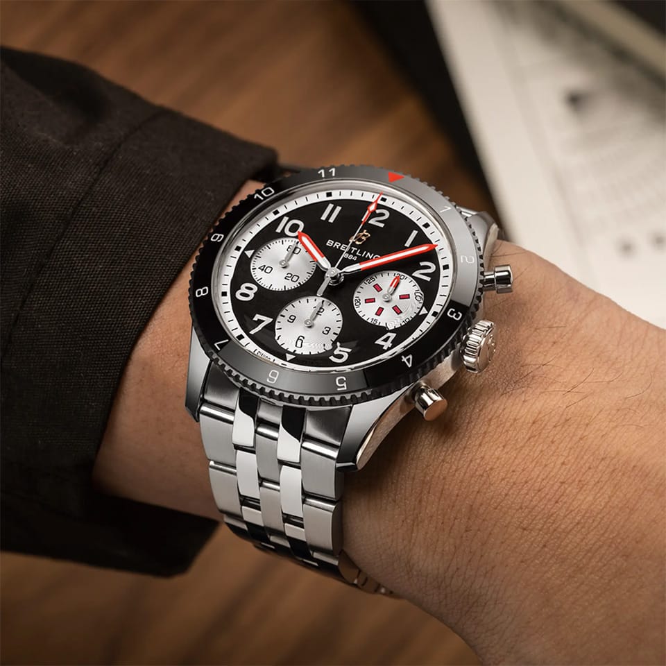 Breitling Classic AVI Automatic Chronograph 42mm Watch Y233801A1B1A1 is shown worn on the wrist, highlighting the proportions of its 42mm case and stainless steel bracelet. This COSC-certified chronograph is powered by the Breitling Caliber 23 with an approximate 48-hour power reserve.